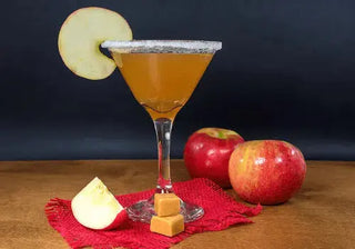 Caramel apple mocktail in a martini glass with apple slices