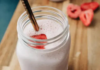 Strawberry banana smoothie in a glass with fresh fruit
