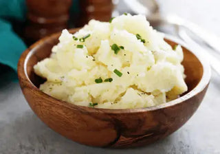 Bowl of creamy mashed potatoes with garnish