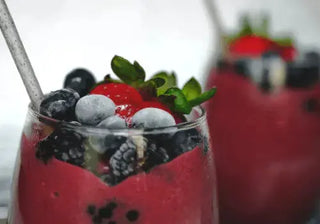 Fruit smoothie in a glass with fresh berries on the side