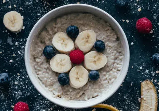 Bowl of oatmeal topped with fruit and seeds